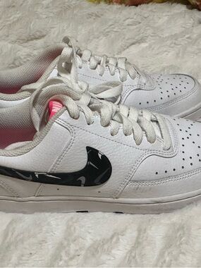 Nike White Low-Top Sneakers with Black Patterned Swoosh and Pink Tongue Accent
